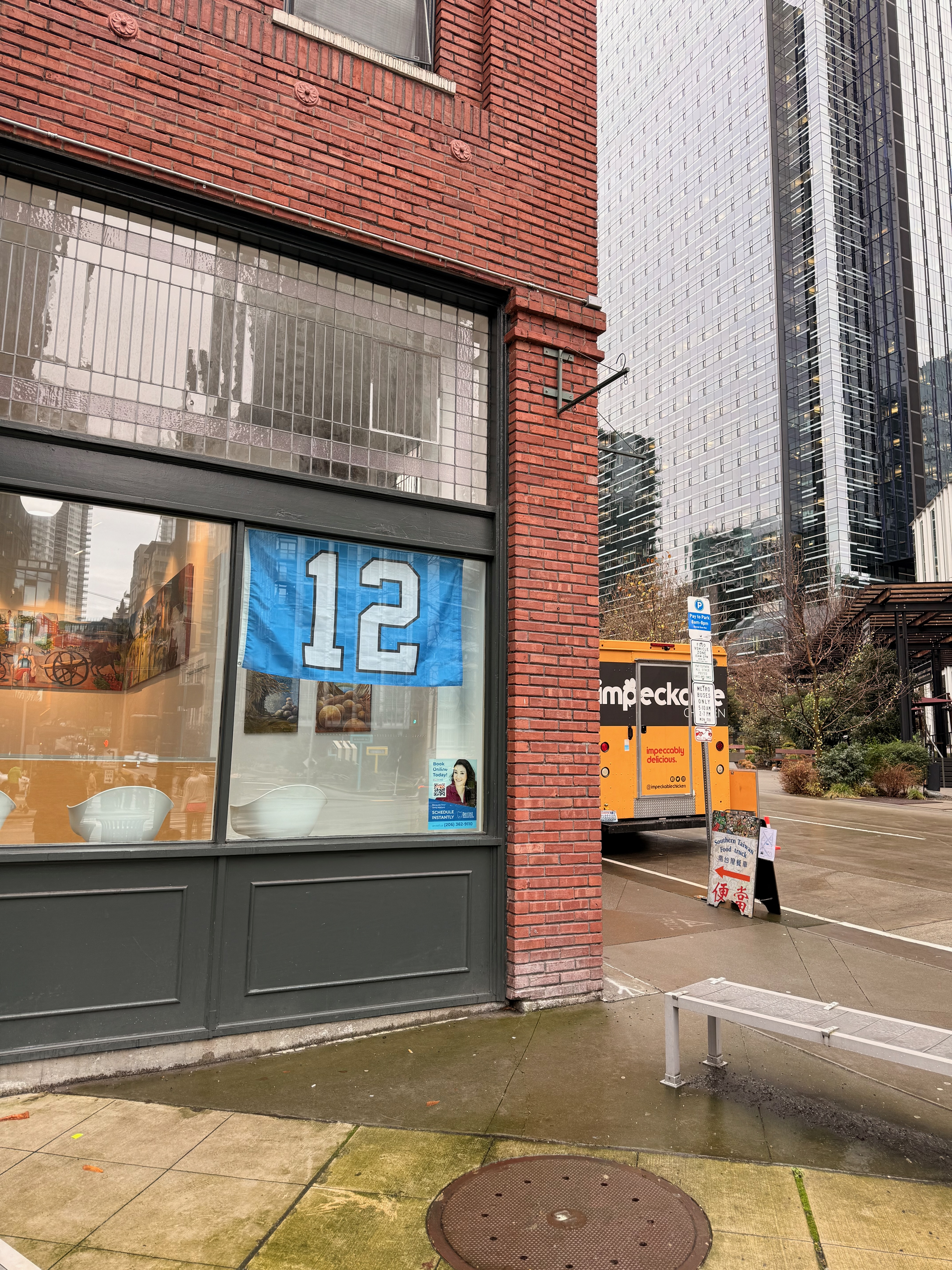 A 12 flag displayed in a storefront window of a brick building