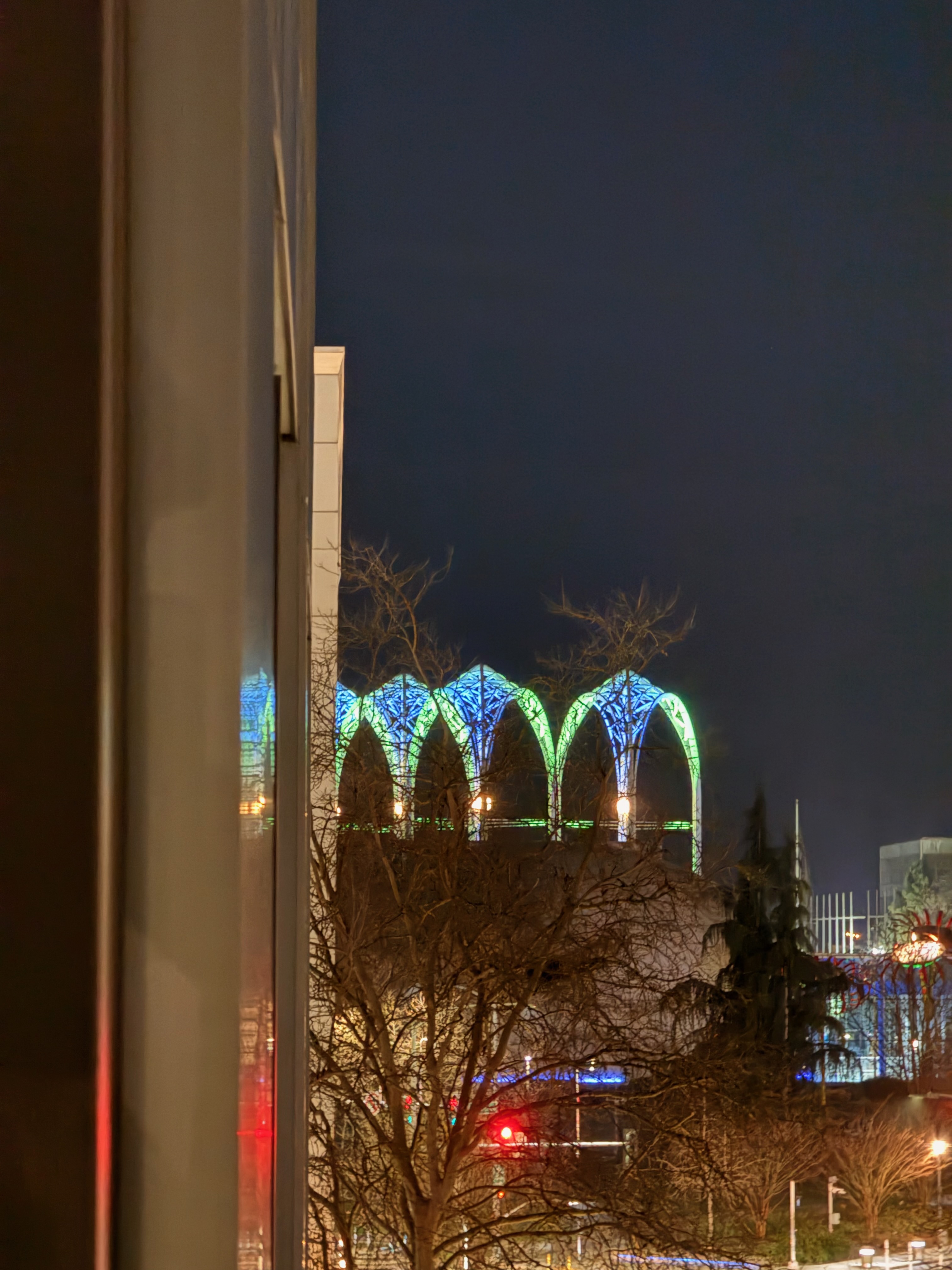 Pacific Science Center arches lit up in blue and green at night